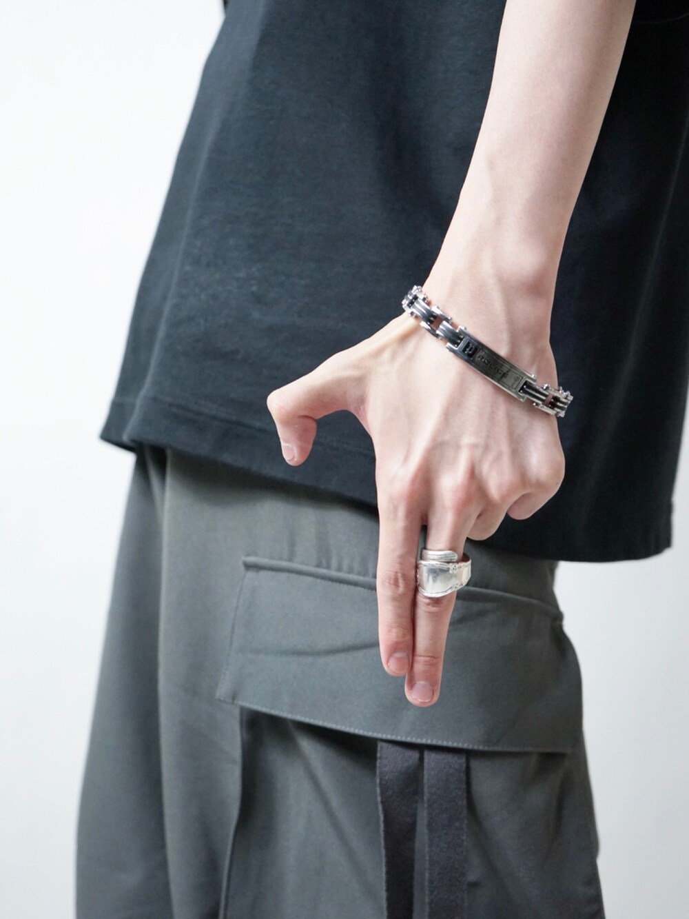 ブラック系のタンクトップ、ブラック系のスラックス、ホワイト系のカーディガン/ボレロを着用したメンズの夏コーディネートの2枚目の写真