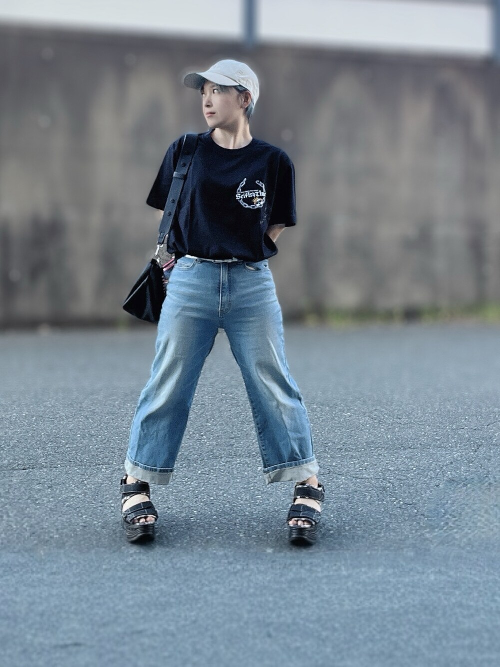 ブラック系のTシャツ/カットソー、ブルー系のデニムパンツ、ブラック系のハンドバッグを着用したレディースの秋コーディネートの4枚目の写真