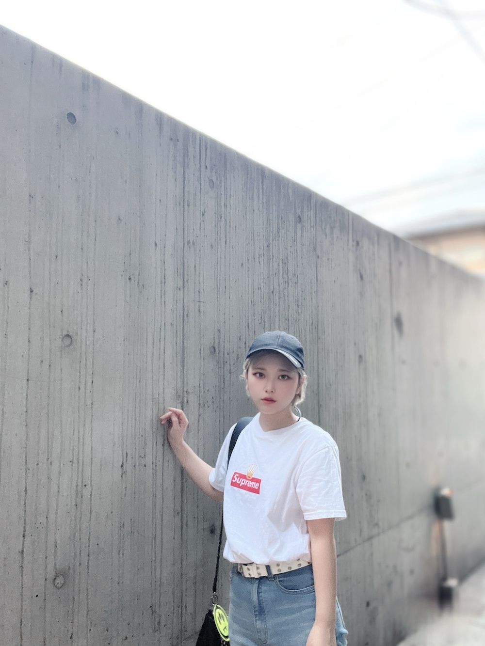 ホワイト系のTシャツ/カットソー、ブラック系のサンダル、ブルー系のデニムパンツを着用したレディースの夏コーディネートの4枚目の写真