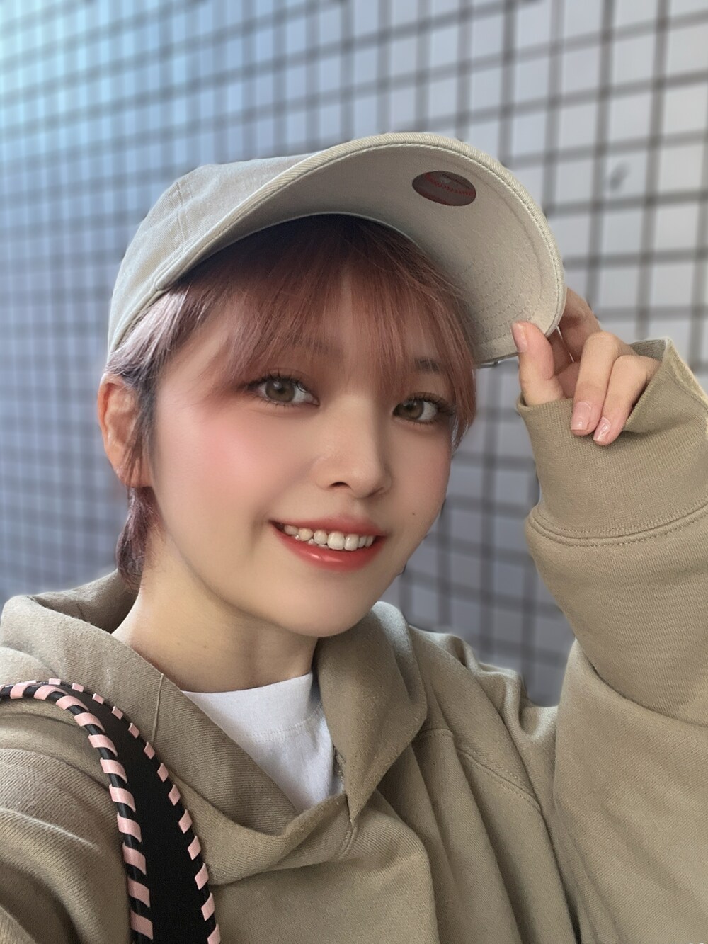 ベージュ系のパーカー、ブラック系のサンダル、ブラック系のハンドバッグを着用したレディースの秋コーディネートの2枚目の写真