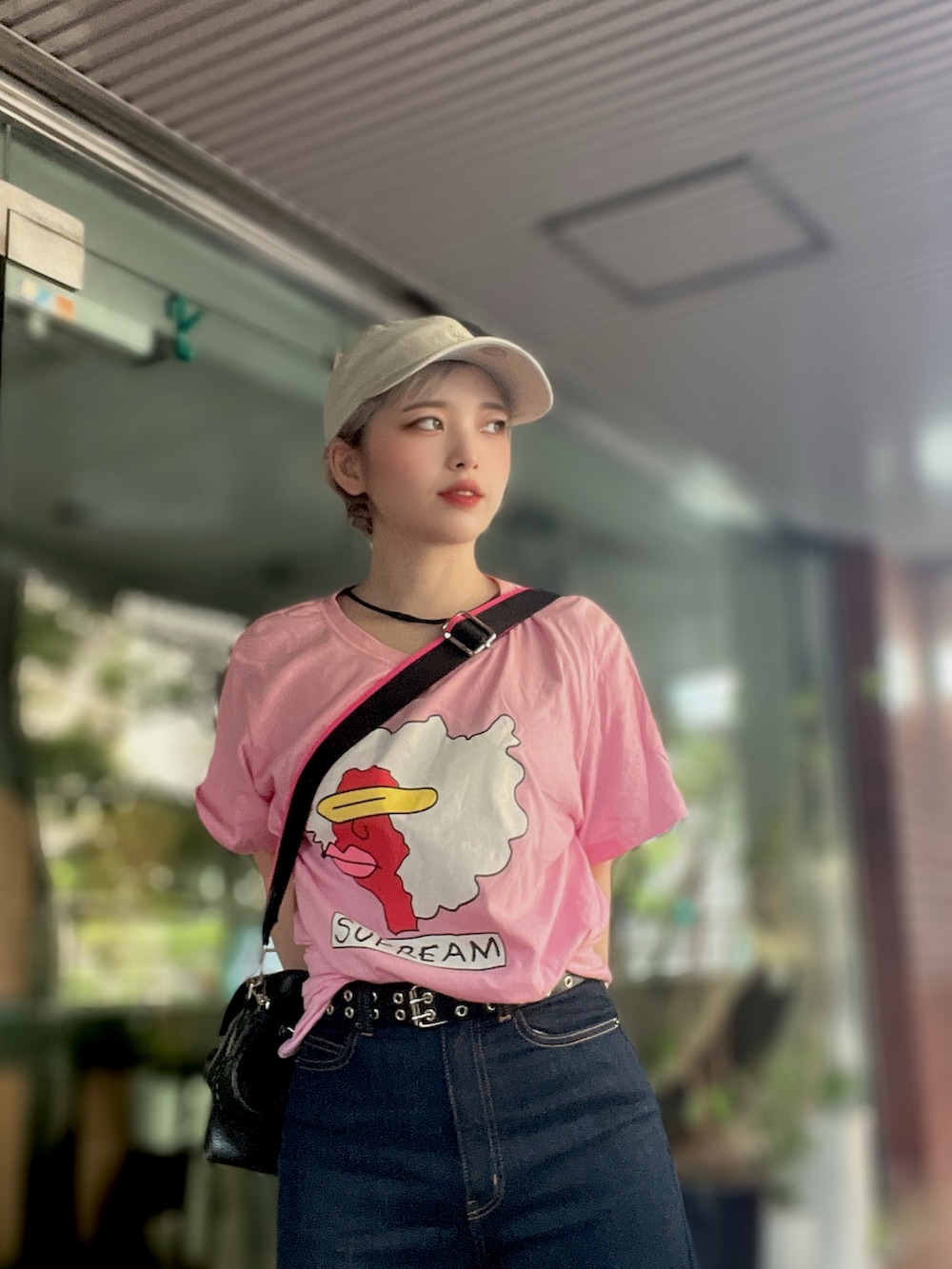 ピンク系のTシャツ/カットソー、ブラック系のボディバッグ/ウエストポーチ、ベージュ系のキャップを着用したレディースの夏コーディネートの2枚目の写真