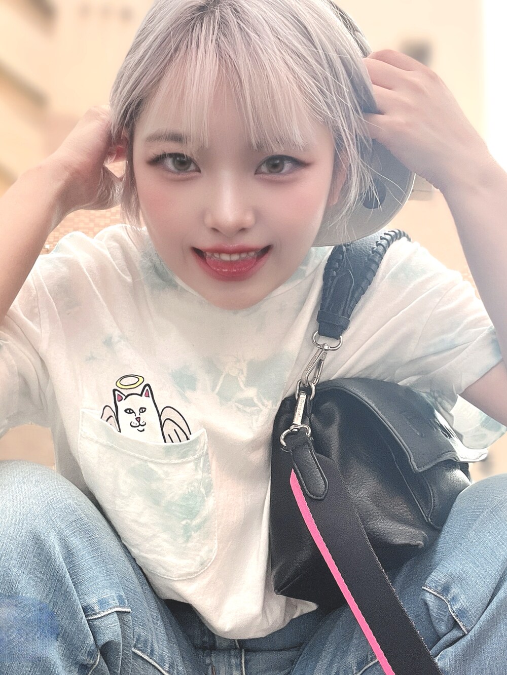 ホワイト系のトップス、ブラック系のボディバッグ/ウエストポーチ、ベージュ系のキャップを着用したレディースの夏コーディネートの4枚目の写真