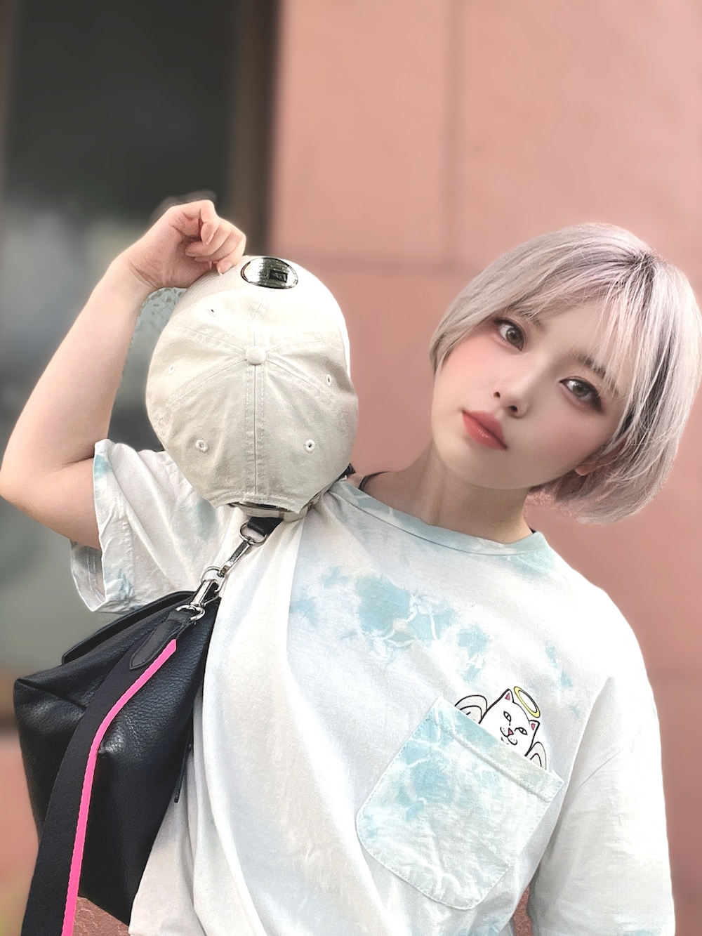 ホワイト系のトップス、ブラック系のボディバッグ/ウエストポーチ、ベージュ系のキャップを着用したレディースの夏コーディネートの2枚目の写真