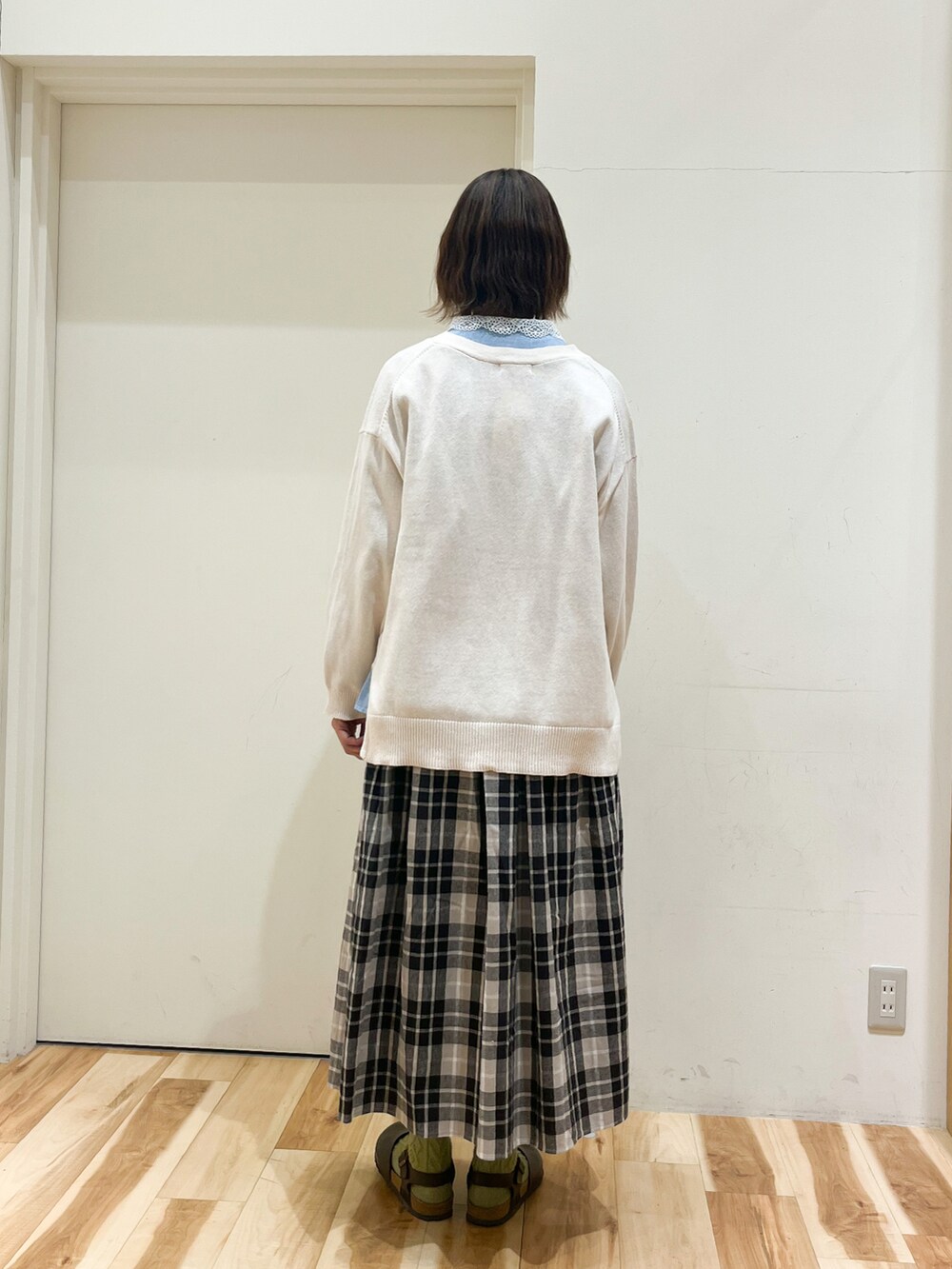 ホワイト系のカーディガン/ボレロ、ブルー系のシャツ/ブラウス、ブラック系のスカートを着用したレディースの春コーディネートの2枚目の写真