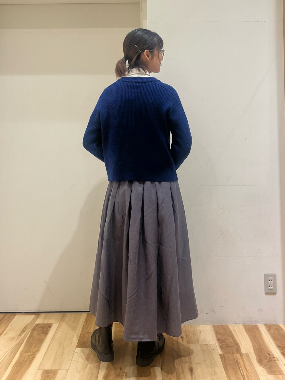 ブルー系のカーディガン/ボレロ、ホワイト系のシャツ/ブラウス、グレー系のスカートを着用したレディースの秋コーディネートの2枚目の写真