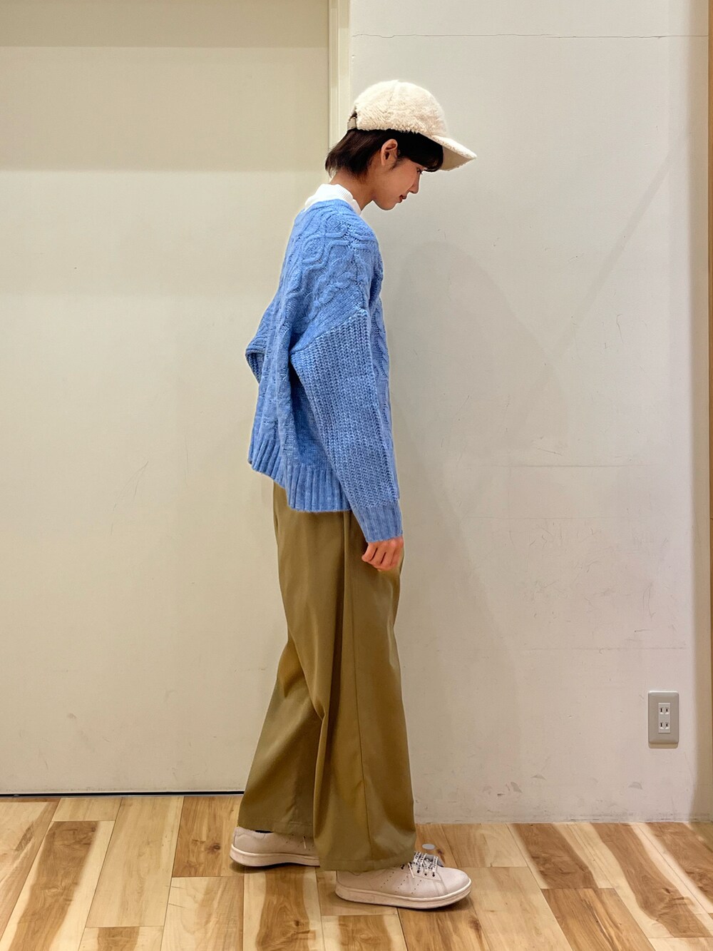 ブルー系のブルゾン、ブルー系のカーディガン/ボレロ、ベージュ系のスラックスを着用したレディースの冬コーディネートの4枚目の写真