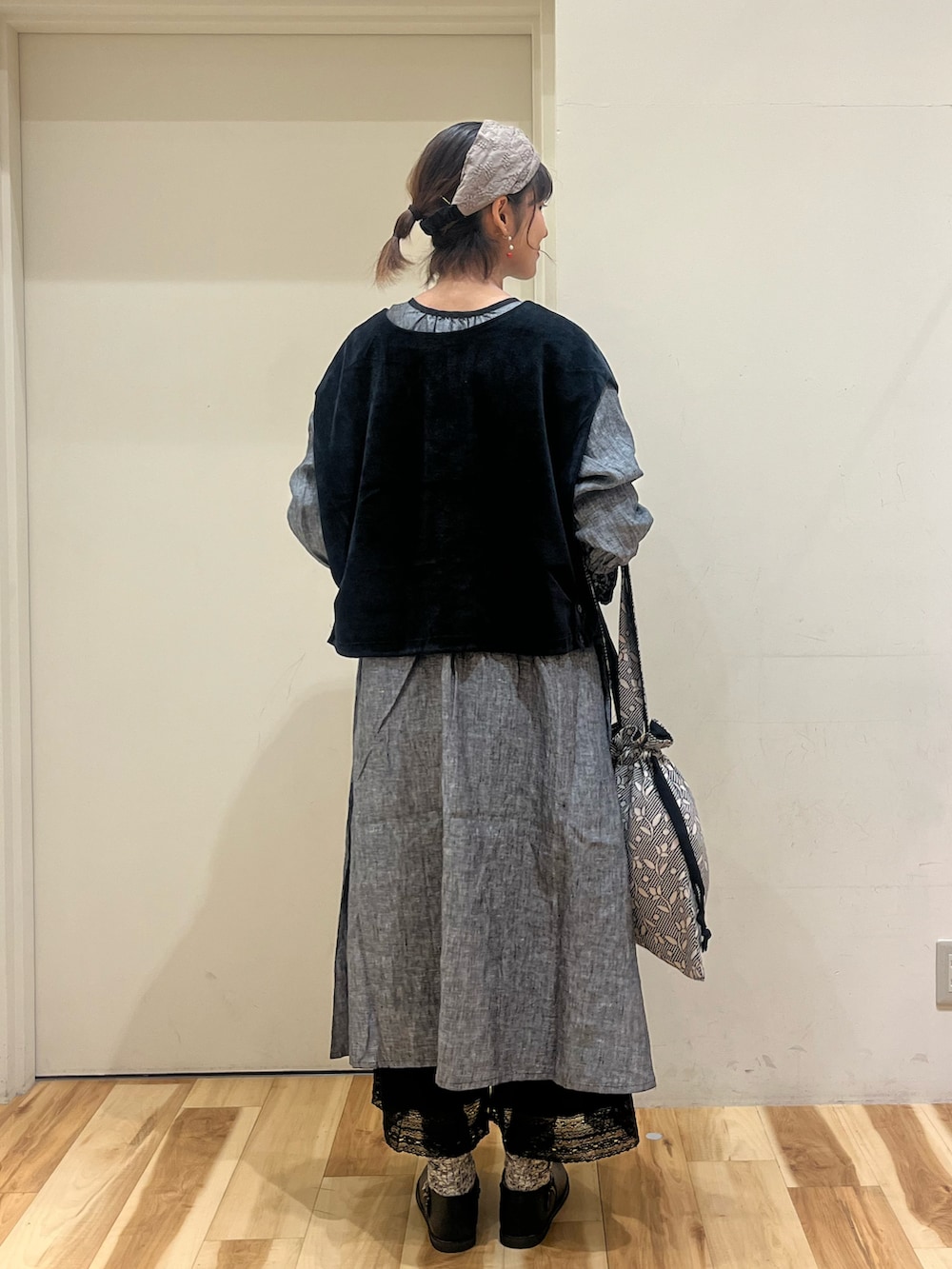 ブラック系のドレスシューズ、ブラック系のベスト、ブラック系のハンドバッグを着用したレディースの秋コーディネートの2枚目の写真