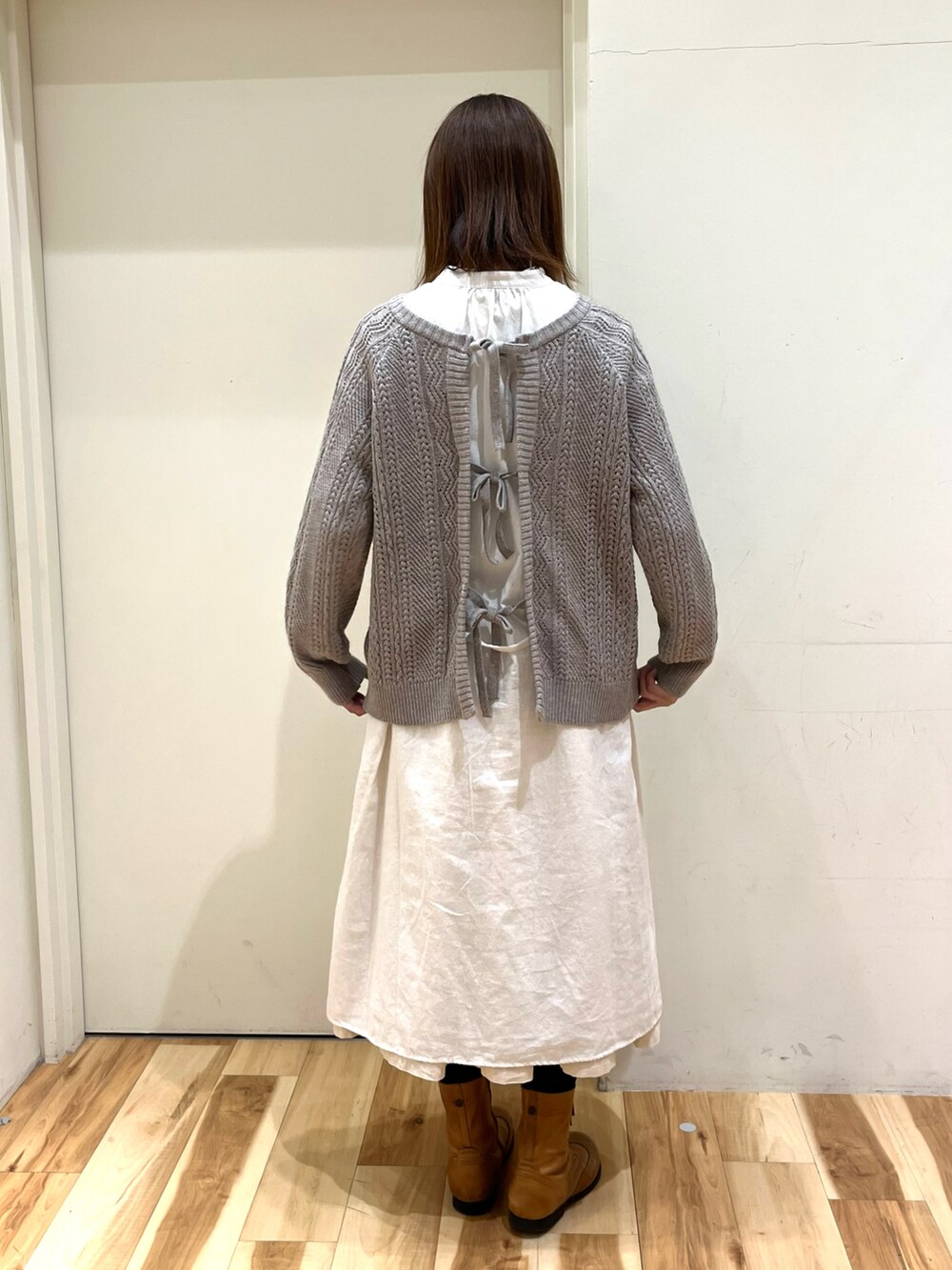 ホワイト系のワンピース、ベージュ系のニット/セーターを着用したレディースの冬コーディネートの2枚目の写真