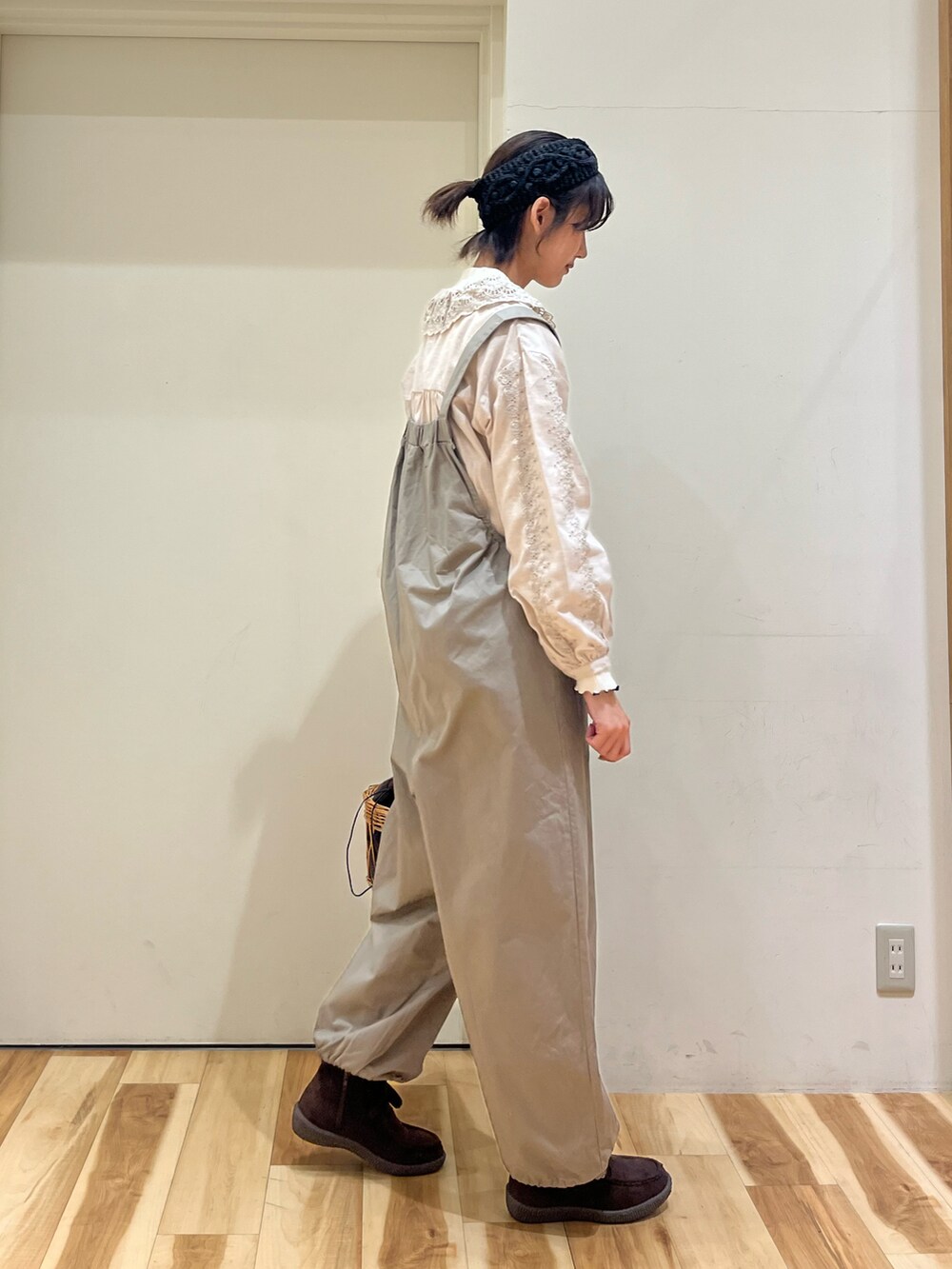 ブラウン系のサロペット/オーバーオール、ベージュ系のシャツ/ブラウス、ブラウン系のハンドバッグを着用したレディースの冬コーディネートの2枚目の写真