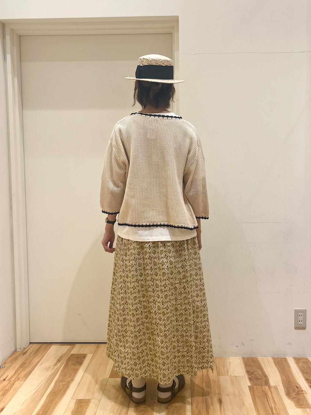 ホワイト系のTシャツ/カットソー、ホワイト系のカーディガン/ボレロ、ベージュ系のスカートを着用したレディースの春コーディネートの2枚目の写真