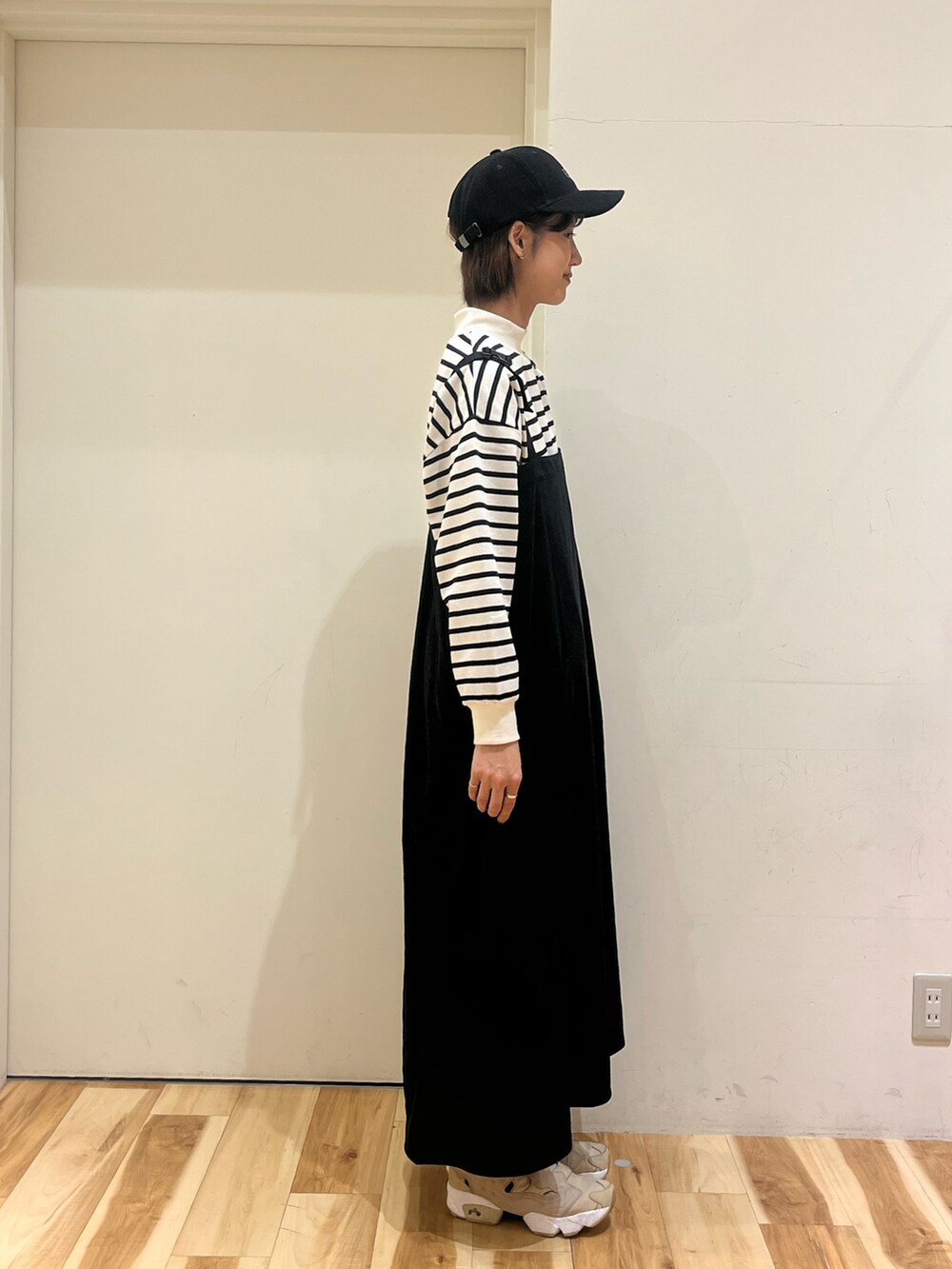 ブラック系のワンピース、ホワイト系のTシャツ/カットソー、ブラック系のハットを着用したレディースの秋コーディネートの2枚目の写真