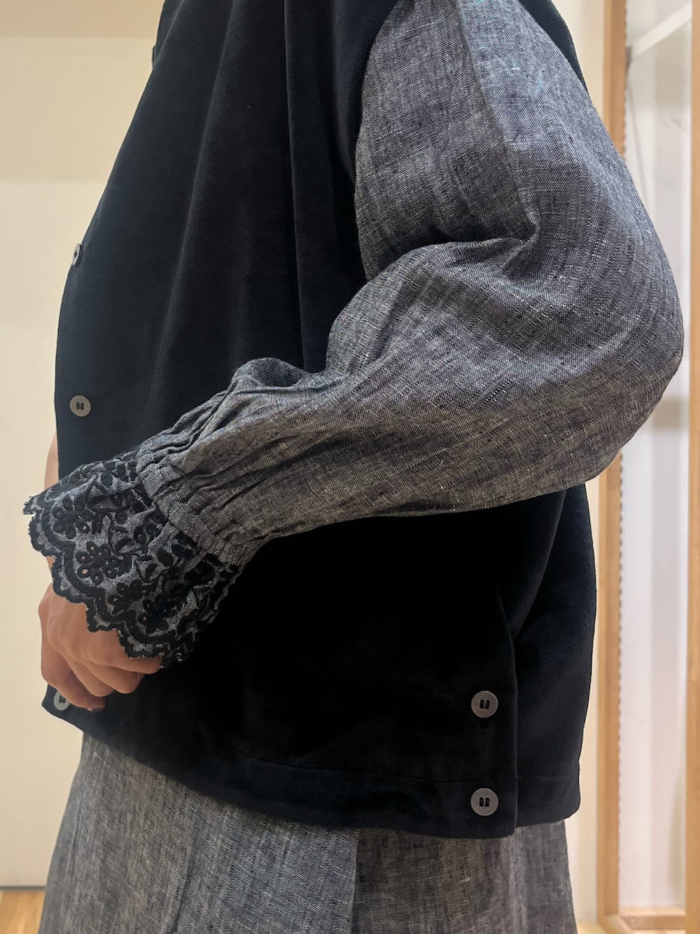 ブラック系のドレスシューズ、ブラック系のベスト、ブラック系のハンドバッグを着用したレディースの秋コーディネートの3枚目の写真