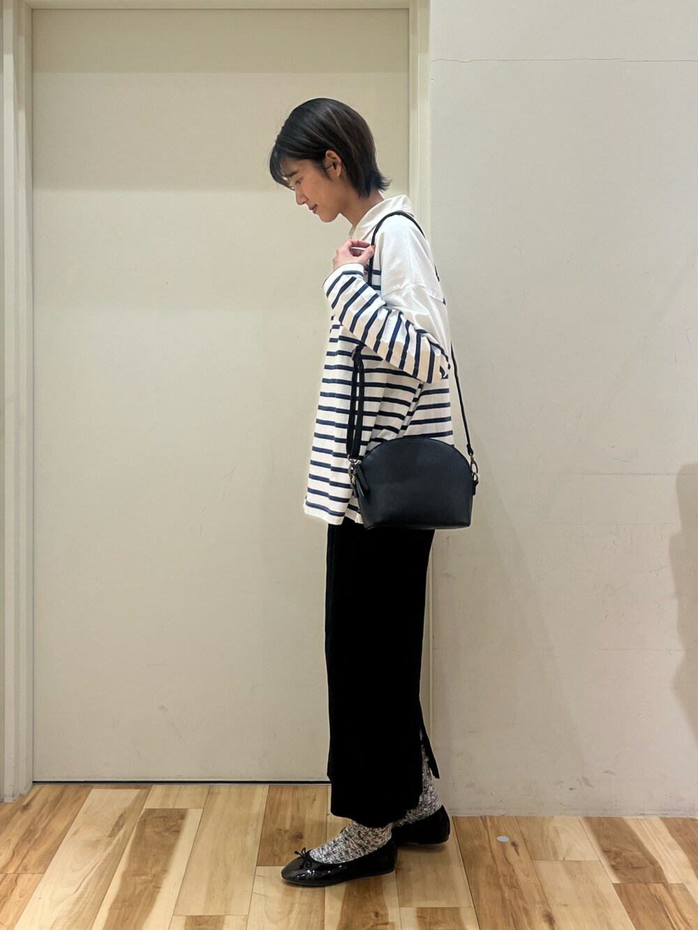 ブラック系のスカート、ブラック系のパンプス、ホワイト系のシャツ/ブラウスを着用したレディースの春コーディネートの2枚目の写真