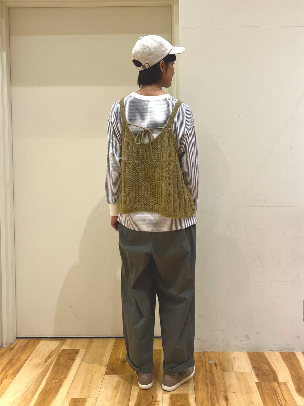 イエロー系のニット/セーター、ブルー系のTシャツ/カットソー、グリーン系のその他パンツを着用したレディースの秋コーディネートの3枚目の写真