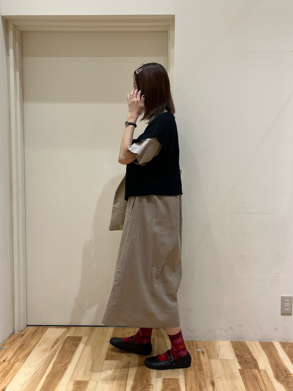 ブラウン系のシャツワンピース、ベージュ系のハンドバッグ、ブラック系のベストを着用したレディースの夏コーディネートの3枚目の写真