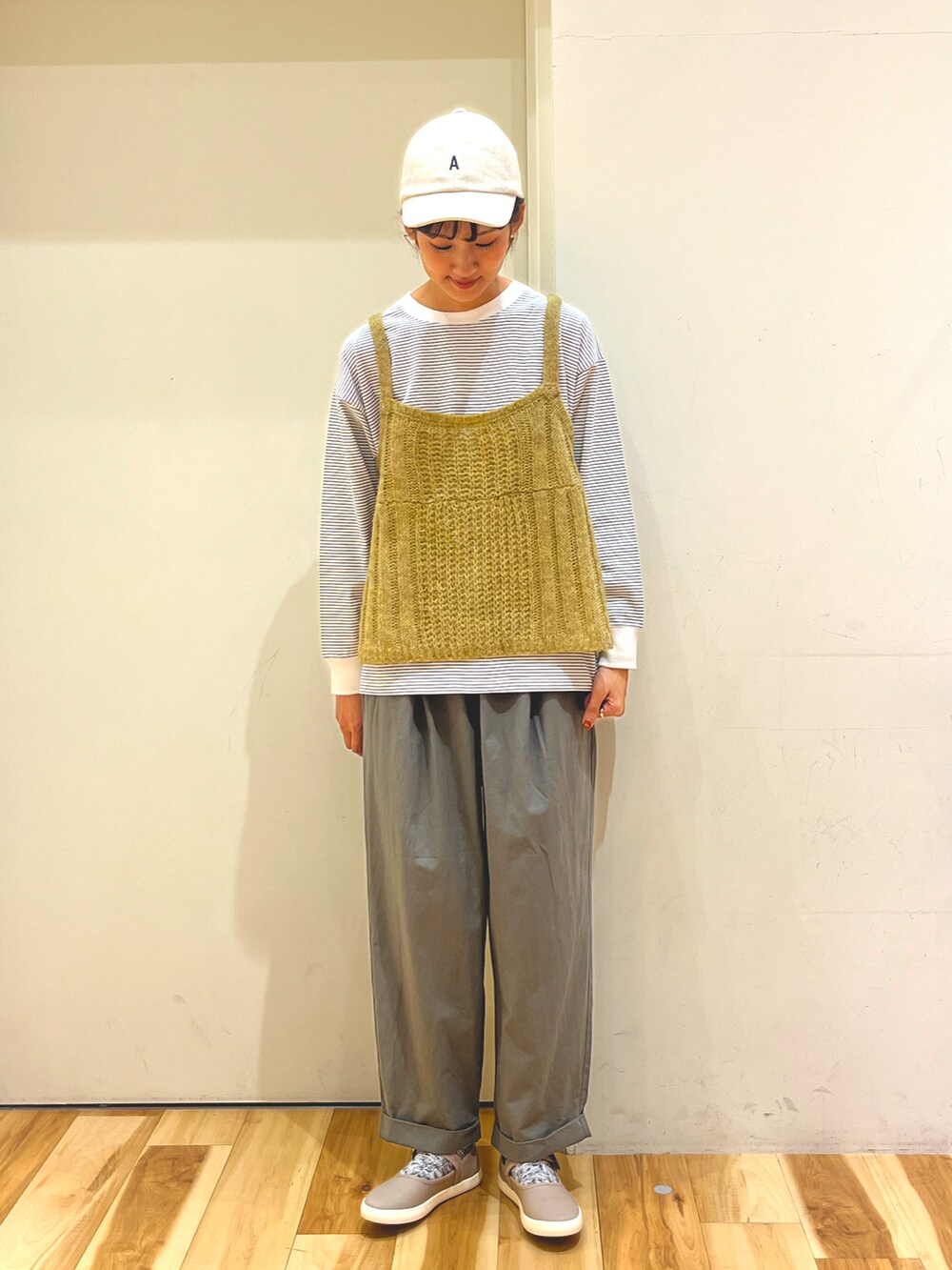 イエロー系のニット/セーター、ブルー系のTシャツ/カットソー、グリーン系のその他パンツを着用したレディースの秋コーディネートの2枚目の写真