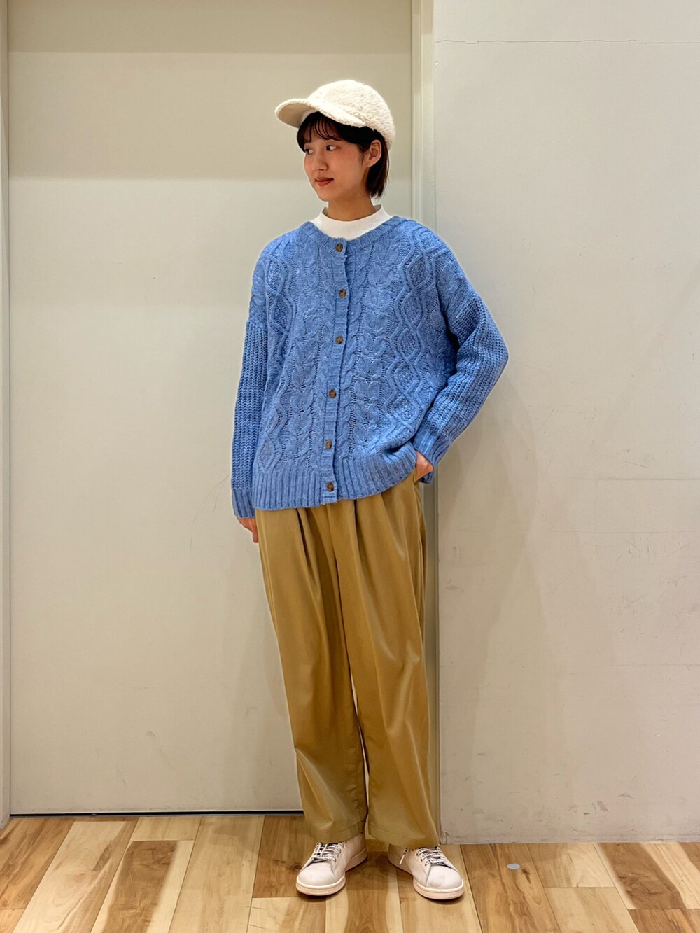 ブルー系のブルゾン、ブルー系のカーディガン/ボレロ、ベージュ系のスラックスを着用したレディースの冬コーディネートの3枚目の写真