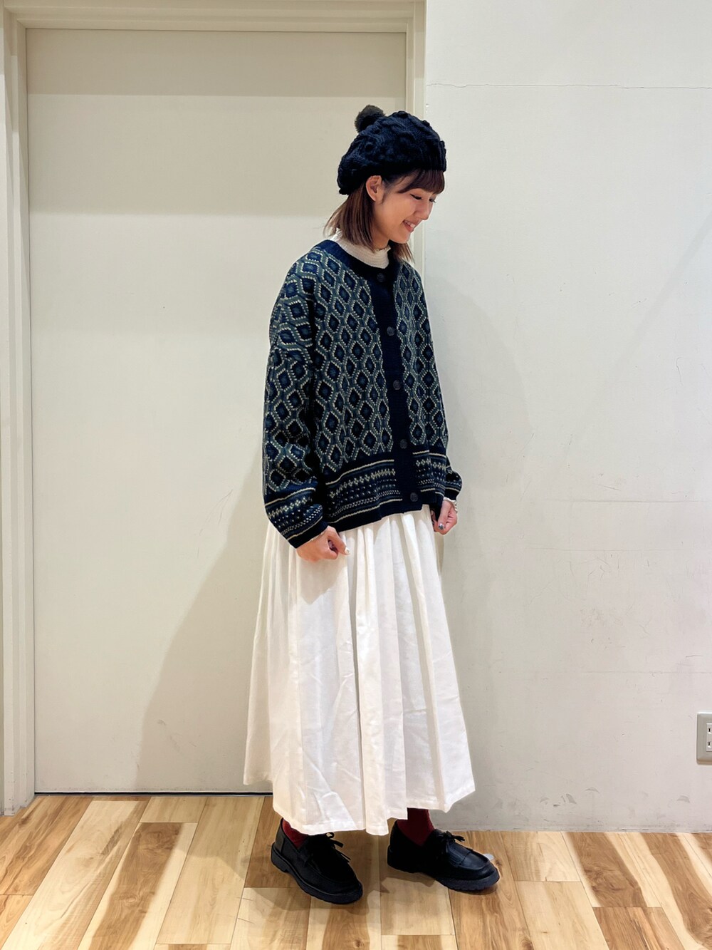 ホワイト系のシャツ/ブラウス、ブルー系のカーディガン/ボレロ、ホワイト系のスカートを着用したレディースの冬コーディネートの2枚目の写真