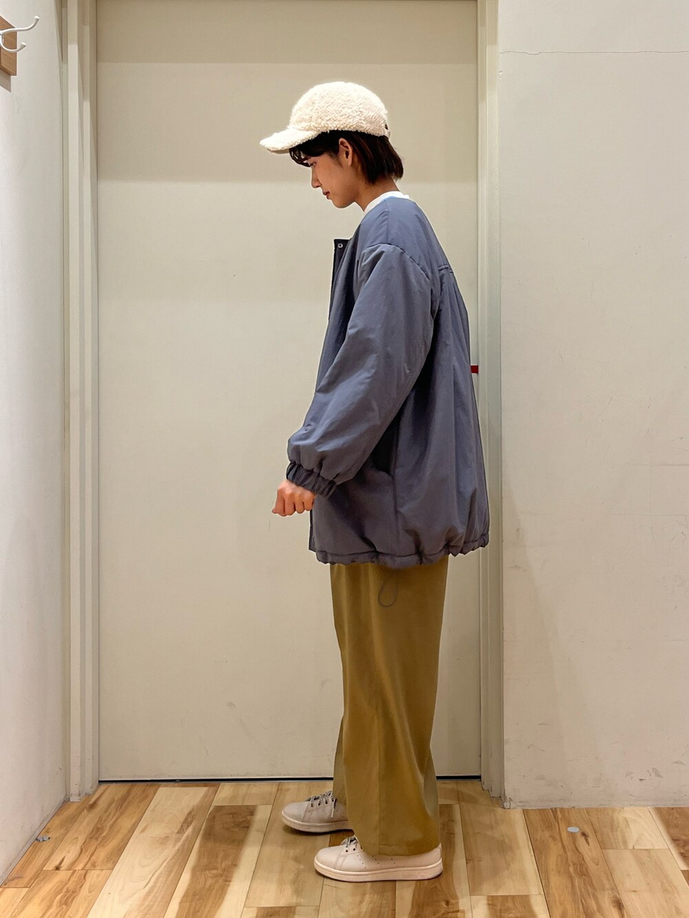 ブルー系のブルゾン、ブルー系のカーディガン/ボレロ、ベージュ系のスラックスを着用したレディースの冬コーディネートの2枚目の写真