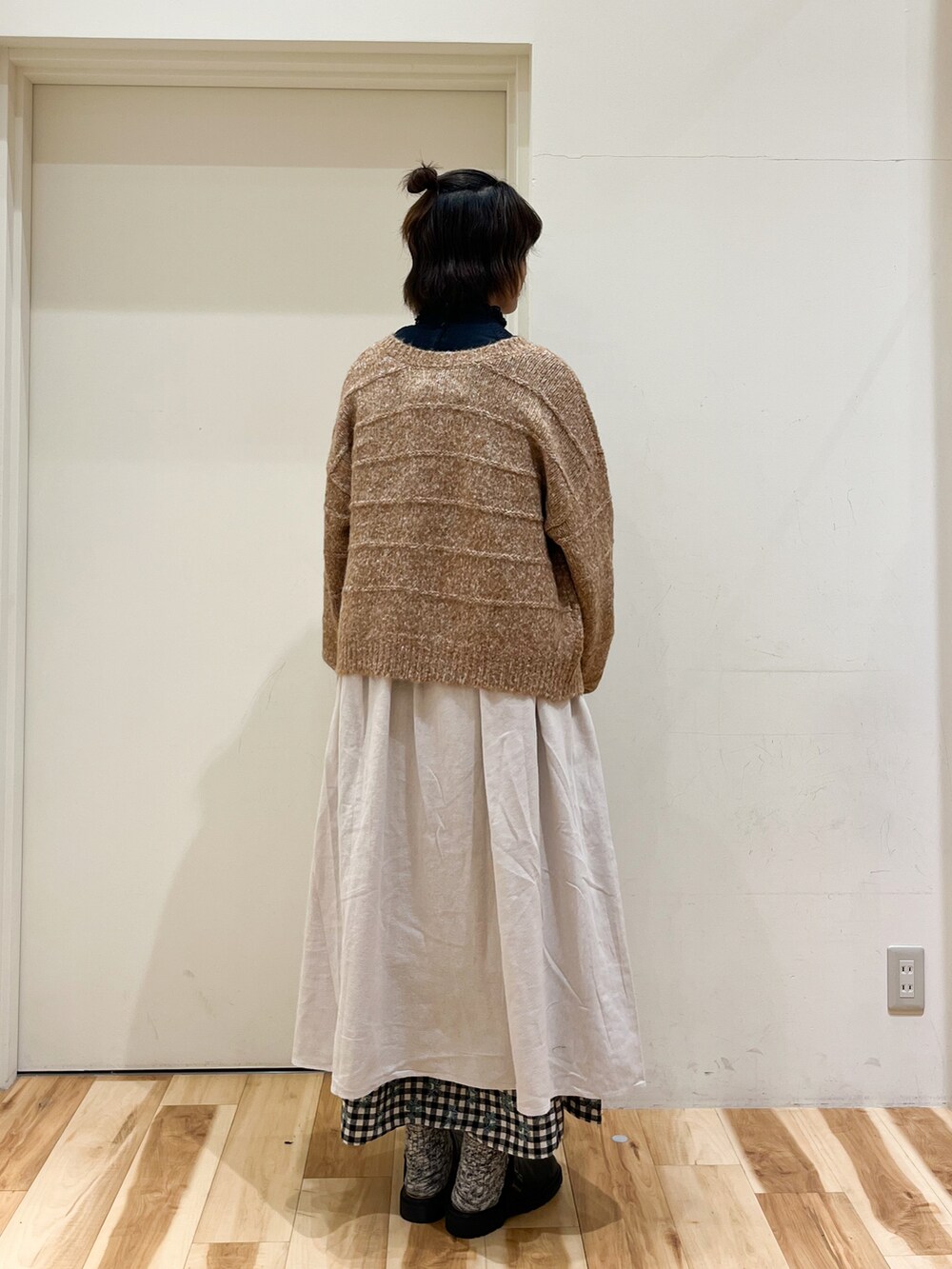 オレンジ系のカーディガン/ボレロ、ブラウン系のシャツ/ブラウス、ホワイト系のワンピースを着用したレディースの秋コーディネートの2枚目の写真