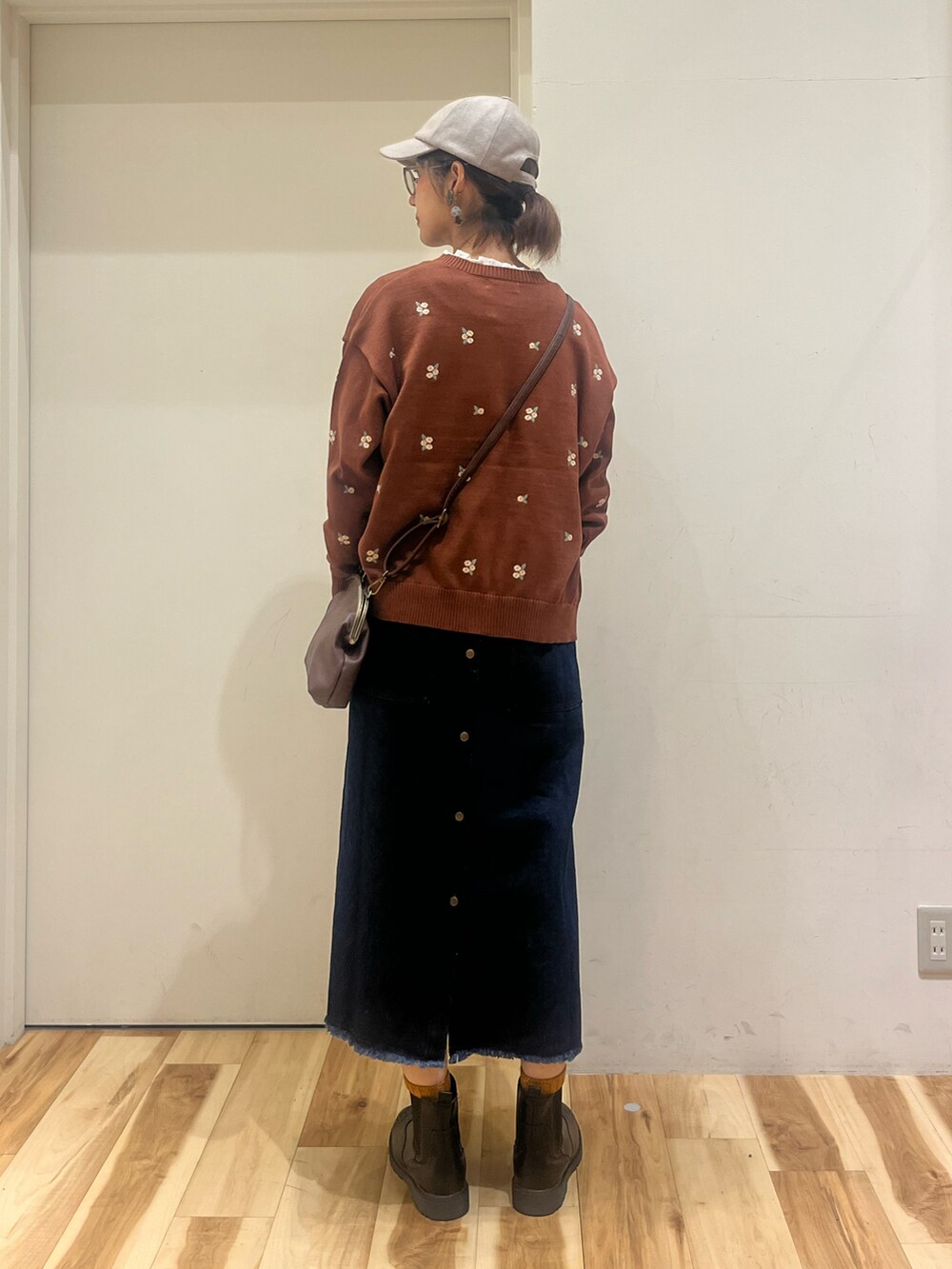 ブラウン系のカーディガン/ボレロ、ホワイト系のシャツ/ブラウス、ブルー系のワンピースを着用したレディースの秋コーディネートの2枚目の写真
