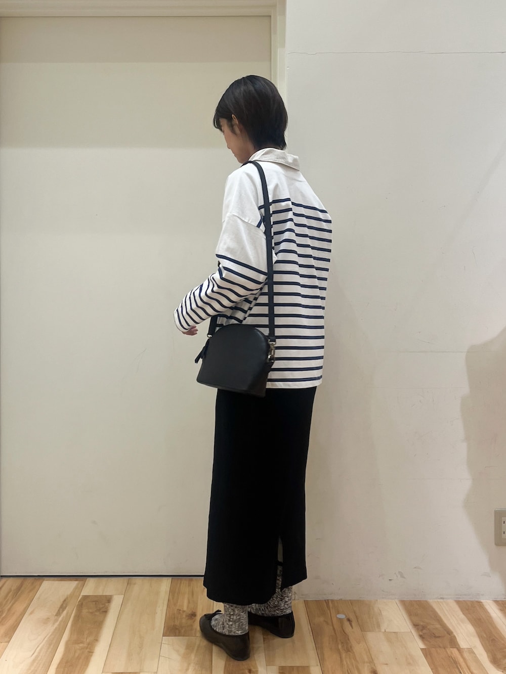 ブラック系のスカート、ブラック系のパンプス、ホワイト系のシャツ/ブラウスを着用したレディースの春コーディネートの3枚目の写真