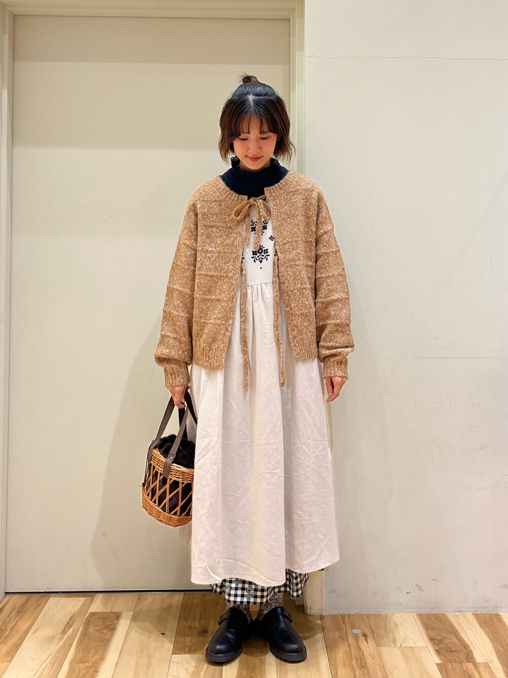 オレンジ系のカーディガン/ボレロ、ブラウン系のシャツ/ブラウス、ホワイト系のワンピースを着用したレディースの秋コーディネートの4枚目の写真