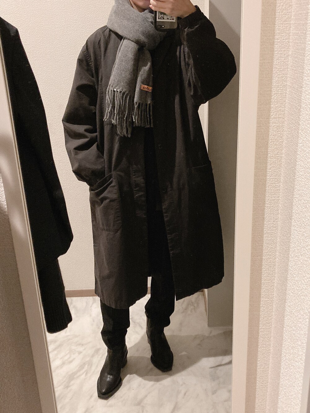 グリーン系のニット/セーター、ブラック系のスラックス、ブラック系のブーツを着用したレディースの秋コーディネートの2枚目の写真