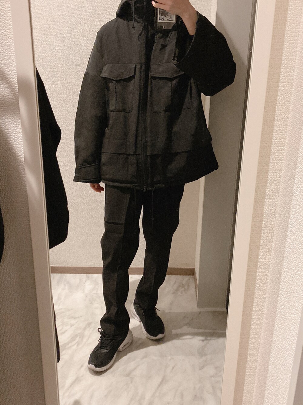 ブラック系のニット/セーター、ブラック系のスラックス、ブラック系のスニーカーを着用したレディースの秋コーディネートの2枚目の写真