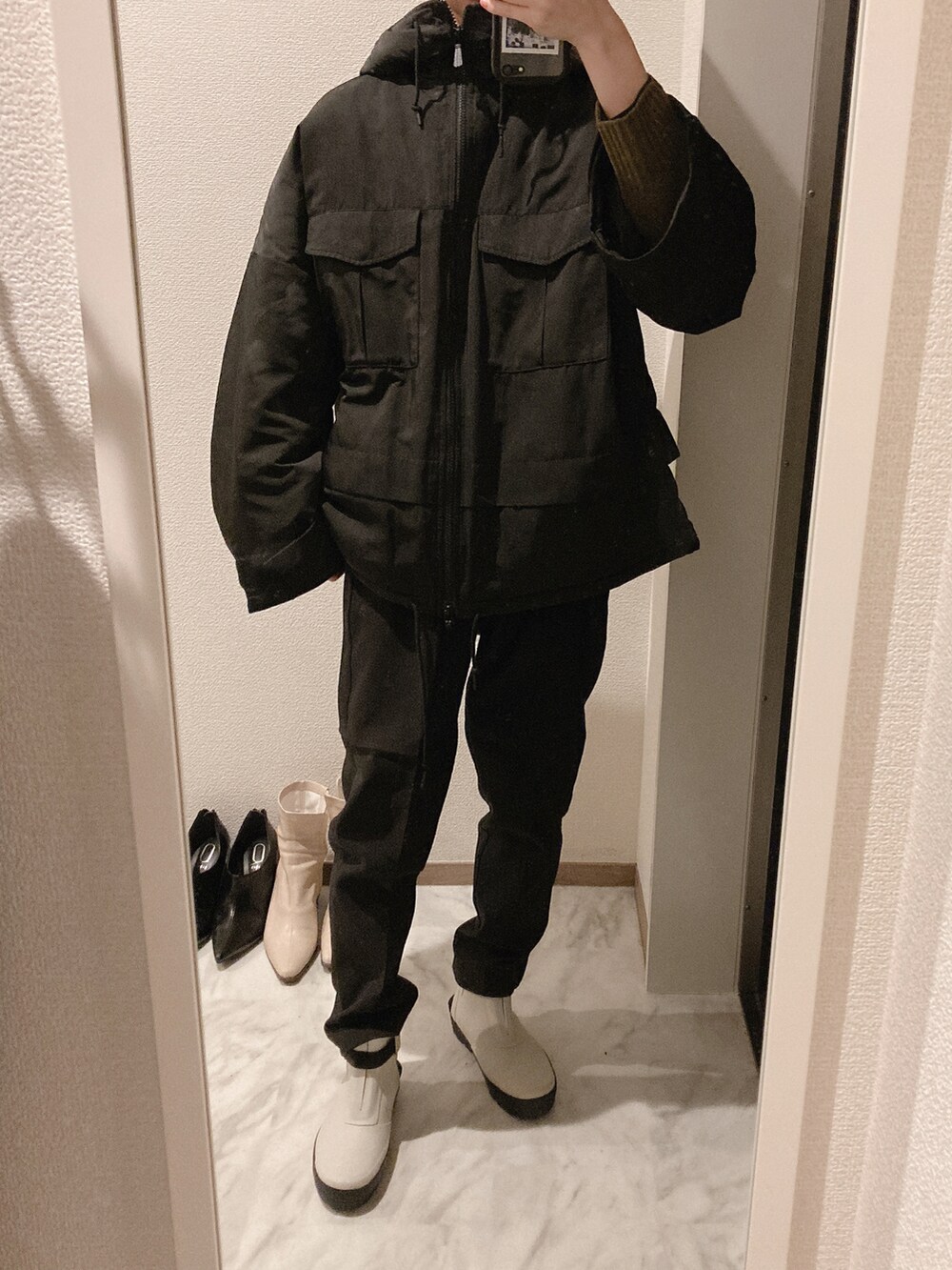 グリーン系のニット/セーター、ホワイト系のレインシューズ、ブラック系のスラックスを着用したレディースの冬コーディネートの2枚目の写真