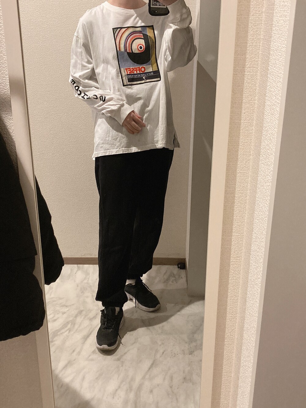 ブラック系のスウェットパンツ、ホワイト系のマウンテンパーカー、ホワイト系のTシャツ/カットソーを着用したレディースの春コーディネートの2枚目の写真