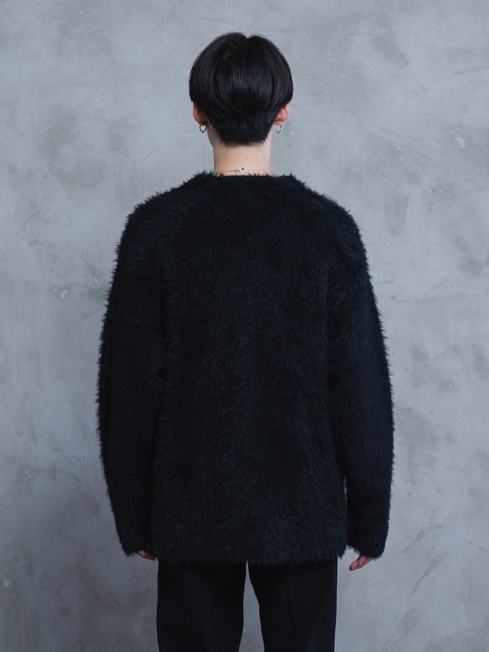 ホワイト系のタンクトップ、ブラック系のデニムパンツ、ブラック系のブーツを着用したメンズの秋コーディネートの4枚目の写真