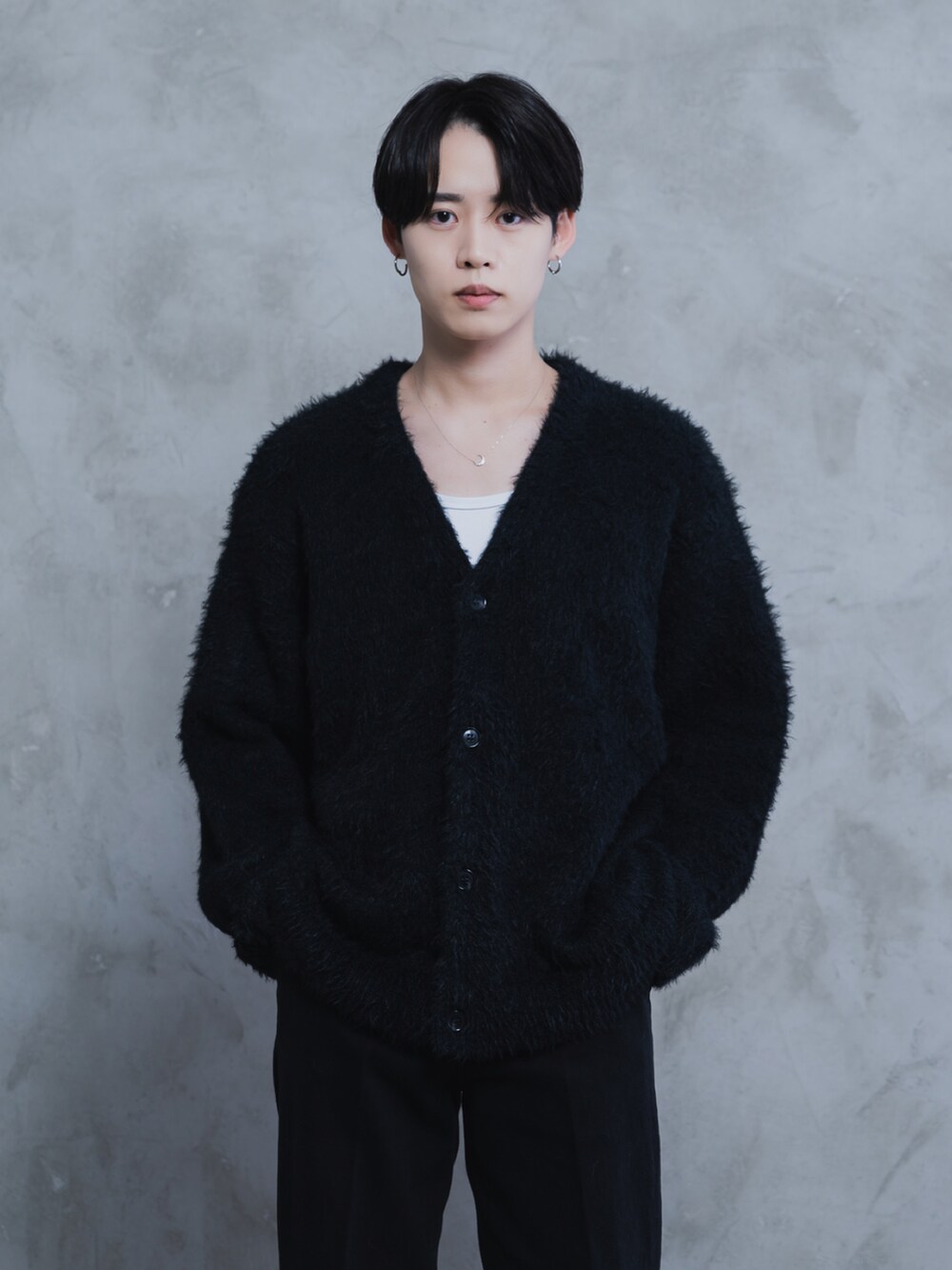 ホワイト系のタンクトップ、ブラック系のデニムパンツ、ブラック系のブーツを着用したメンズの秋コーディネートの2枚目の写真