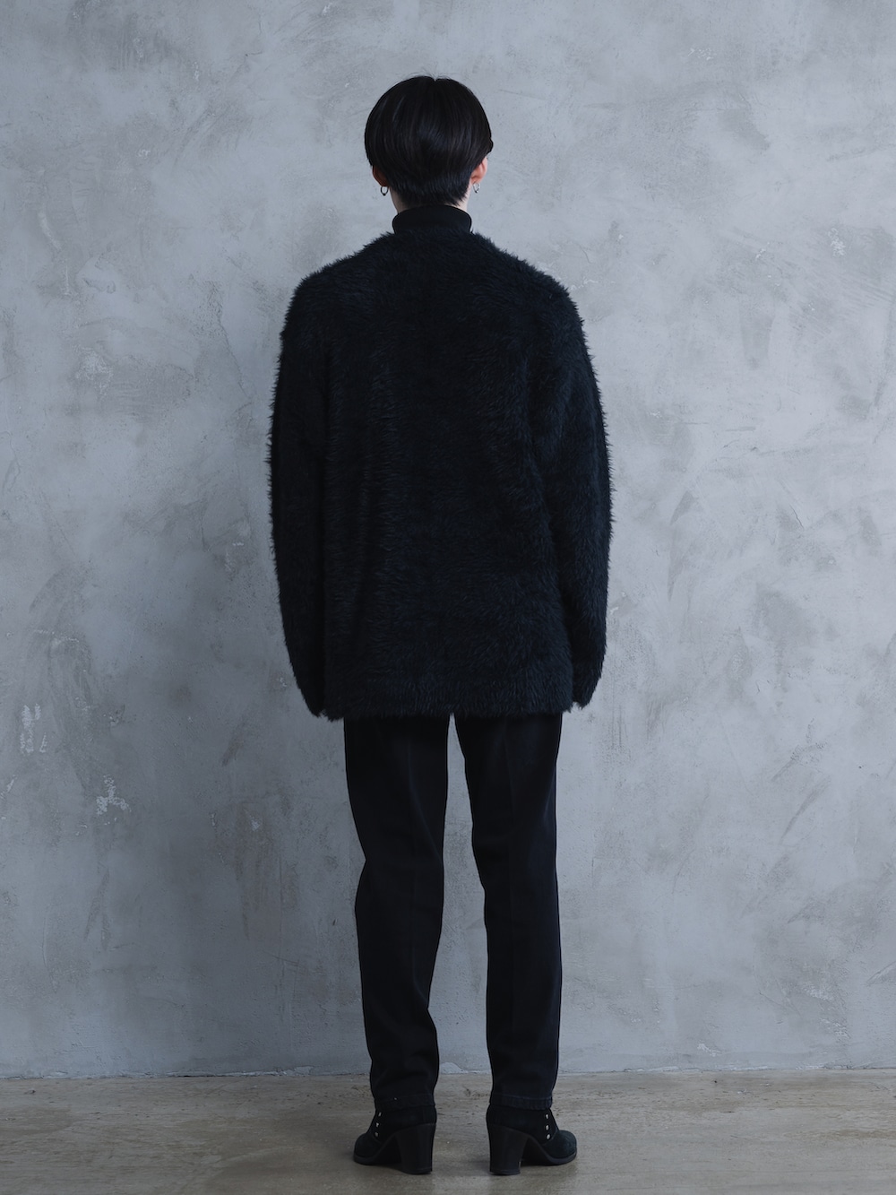 ブラック系のデニムパンツ、ブラック系のブーツ、ブラック系のニット/セーターを着用したメンズの秋コーディネートの3枚目の写真