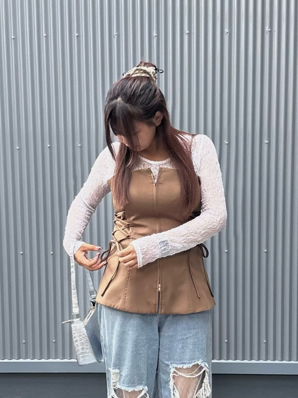 シルバー系のパンプス、ホワイト系のトップス、ブラウン系のキャミソールを着用したレディースの夏コーディネートの2枚目の写真