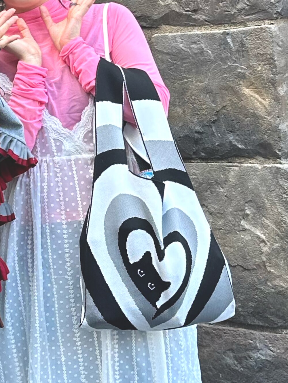 ブラック系のバッグ、ホワイト系のワンピース、ホワイト系のサンダルを着用したレディースの秋コーディネートの2枚目の写真