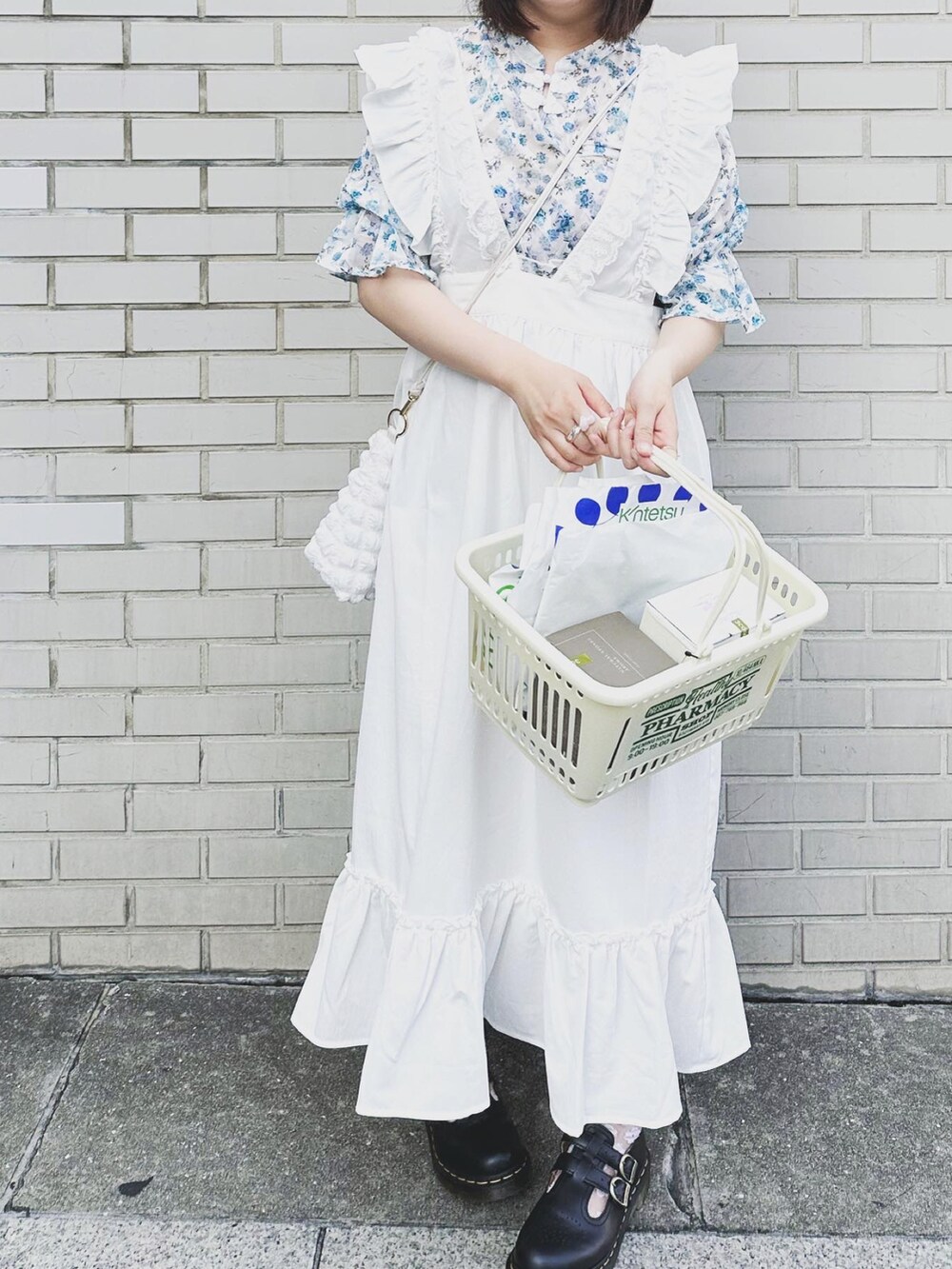 ホワイト系のワンピース、ブルー系のシャツ/ブラウス、ホワイト系のバッグを着用したレディースの夏コーディネートの2枚目の写真