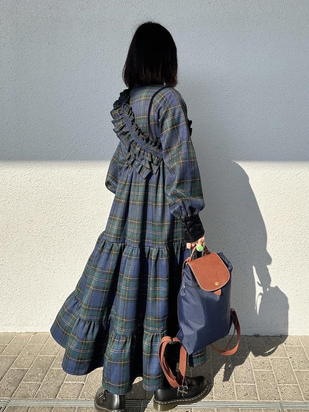 ブルー系のワンピース、ブルー系のバックパック/リュック、ブラック系のシューズを着用したレディースの秋コーディネートの2枚目の写真