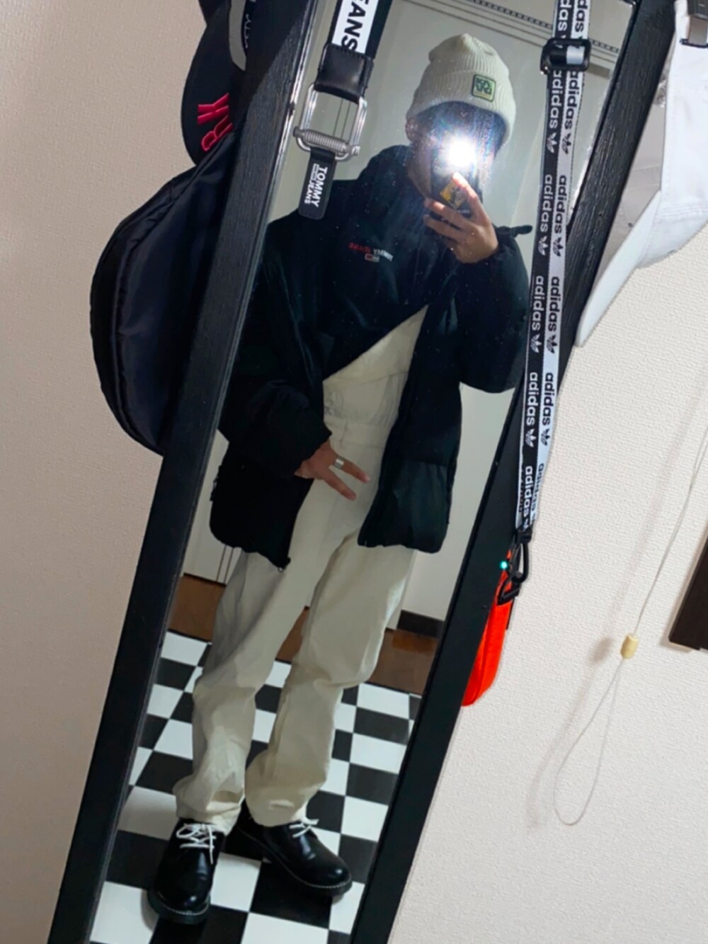 ブラック系のドレスシューズ、ホワイト系のサロペット/オーバーオール、ブラック系のパーカーを着用したメンズの秋コーディネートの2枚目の写真