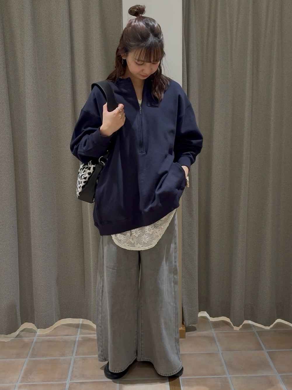 ブルー系のスウェット、ホワイト系のベスト、グレー系のデニムパンツを着用したレディースの冬コーディネートの4枚目の写真