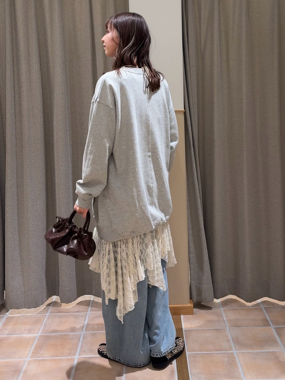 ブラウン系のショルダーバッグ、その他のスニーカー、グレー系のスウェットを着用したレディースの冬コーディネートの2枚目の写真