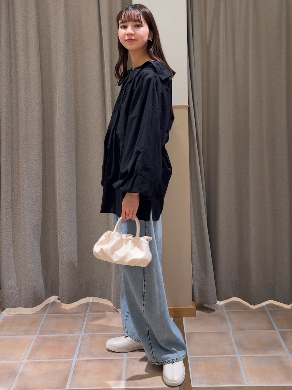 ベージュ系のショルダーバッグ、ホワイト系のスニーカー、ブラック系のシャツ/ブラウスを着用したレディースの冬コーディネートの3枚目の写真