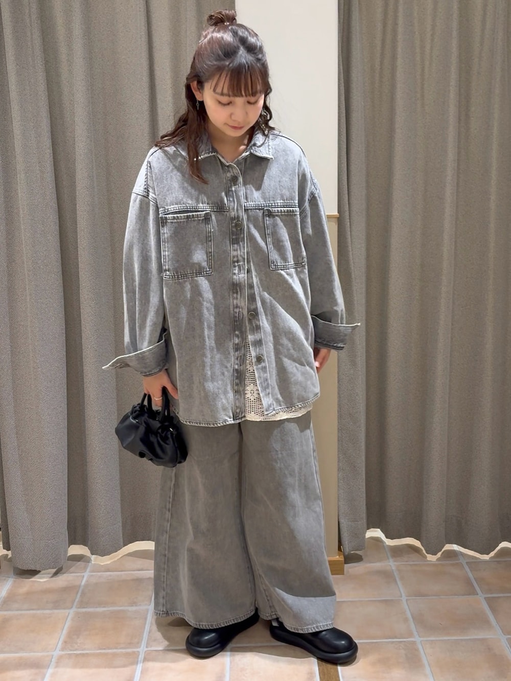 ブラック系のショルダーバッグ、グレー系のシャツ/ブラウス、ホワイト系のベストを着用したレディースの冬コーディネートの4枚目の写真