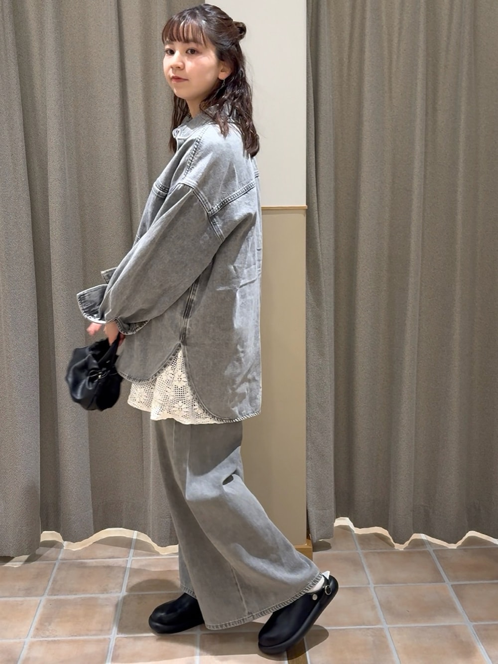 ブラック系のショルダーバッグ、グレー系のシャツ/ブラウス、ホワイト系のベストを着用したレディースの冬コーディネートの2枚目の写真