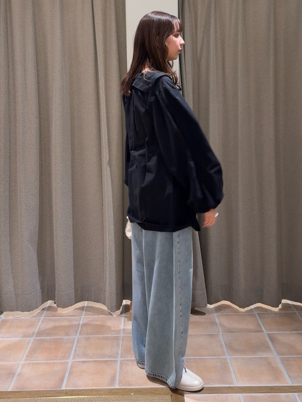 ベージュ系のショルダーバッグ、ホワイト系のスニーカー、ブラック系のシャツ/ブラウスを着用したレディースの冬コーディネートの5枚目の写真