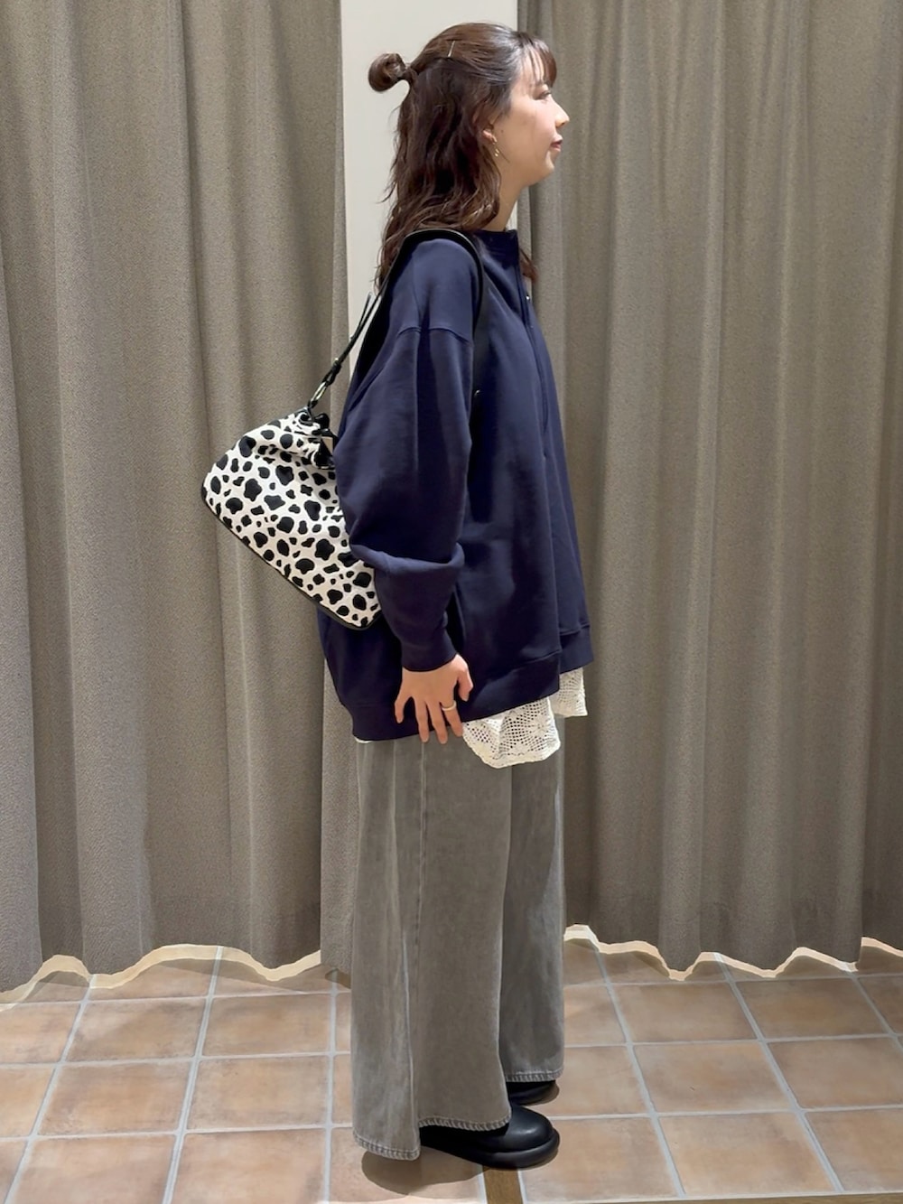 ブルー系のスウェット、ホワイト系のベスト、グレー系のデニムパンツを着用したレディースの冬コーディネートの5枚目の写真