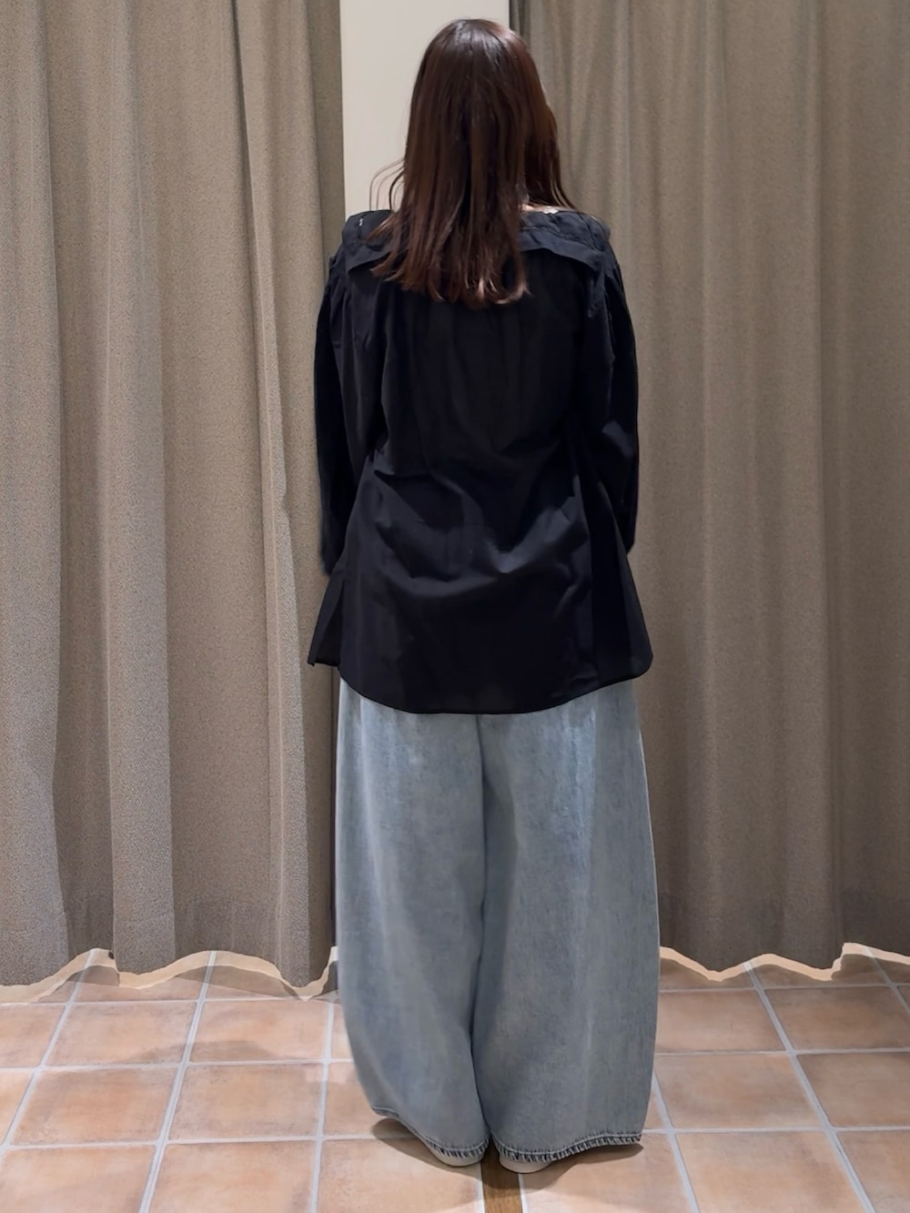 ベージュ系のショルダーバッグ、ホワイト系のスニーカー、ブラック系のシャツ/ブラウスを着用したレディースの冬コーディネートの4枚目の写真