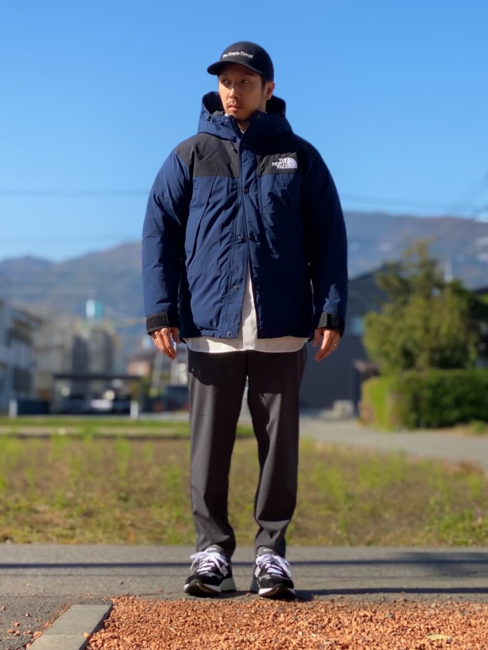 ホワイト系のシャツ/ブラウス、ブルー系のダウンジャケット/コート、グレー系のその他パンツを着用したメンズの秋コーディネートの2枚目の写真