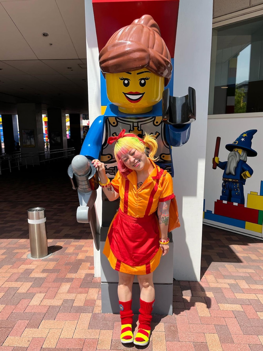 レッド系のレッグウォーマーを着用したレディースの夏コーディネートの2枚目の写真