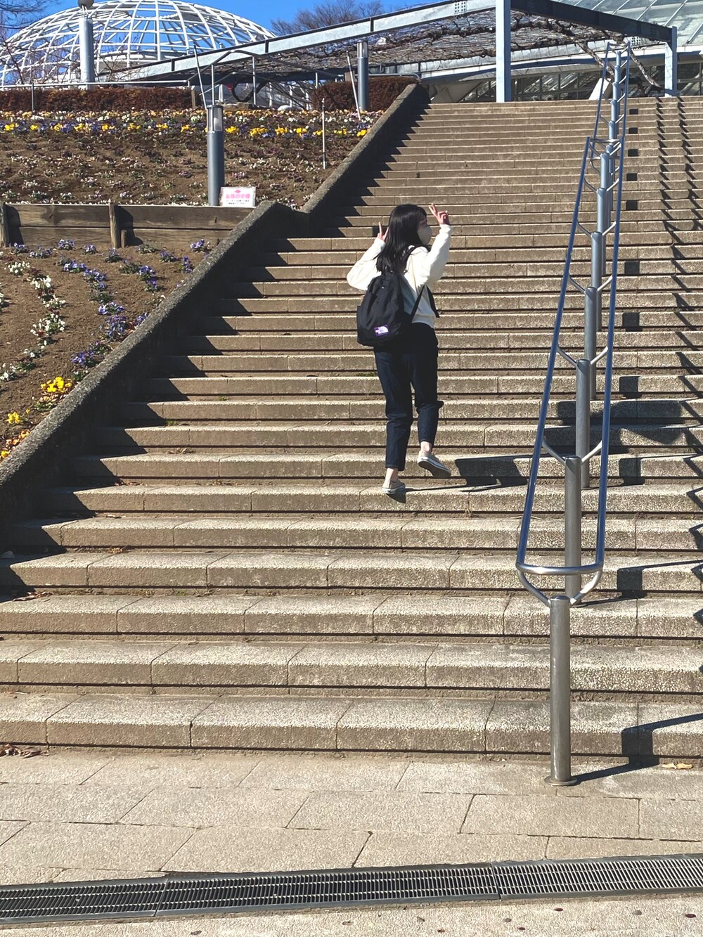 ブルー系のデニムパンツ、ベージュ系のスニーカー、ホワイト系のニット/セーターを着用したレディースの冬コーディネートの3枚目の写真